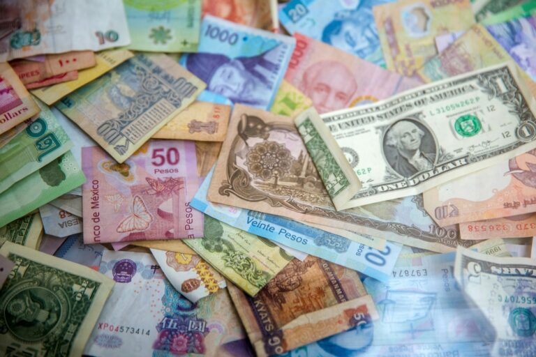 Cédulas de diferentes moedas internacionais espalhadas sobre superfície