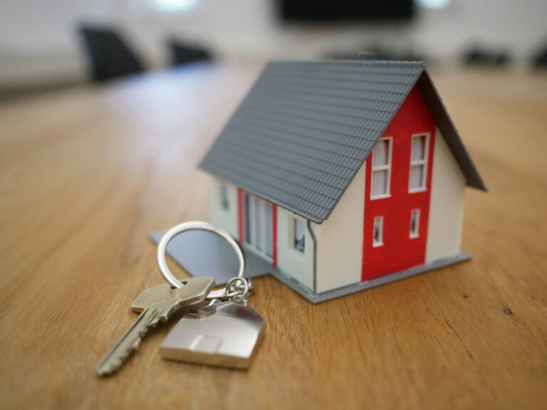 Miniatura de casa sobre mesa de madeira em escritório imobiliário