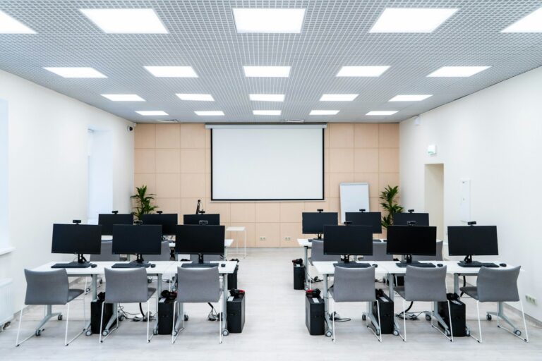 Sala de aula de informática com fileiras de computadores