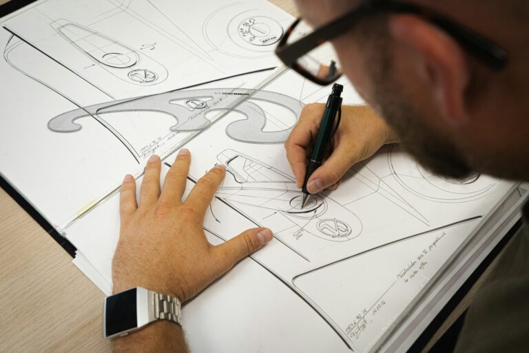 Designer desenhando detalhes de um produto no papel