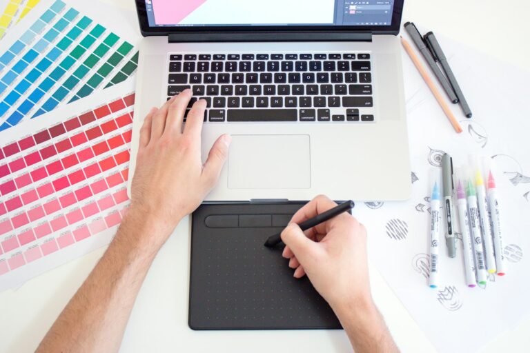 Designer gráfico trabalhando com mesa digitalizadora e cartela de cores