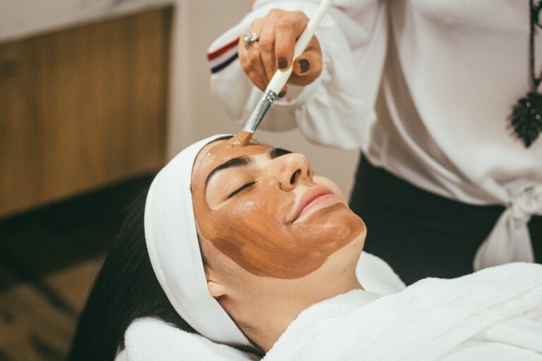 Cliente recebendo tratamento facial com máscara em clínica de estética