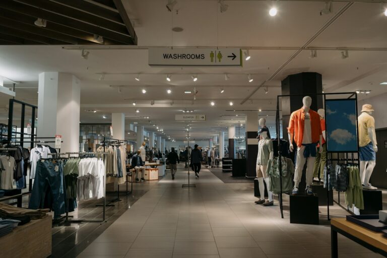 Interior de loja de departamentos com araras de roupas