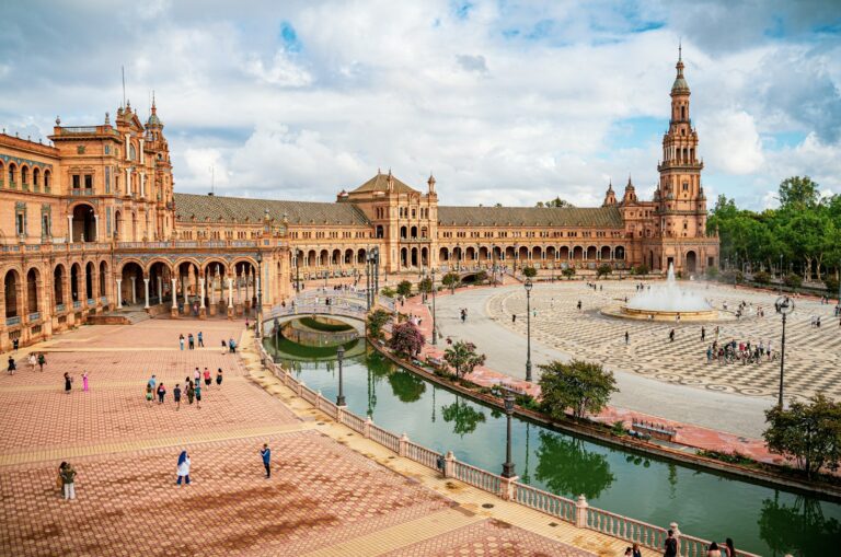 Praça histórica espanhola com fonte e grande edifício