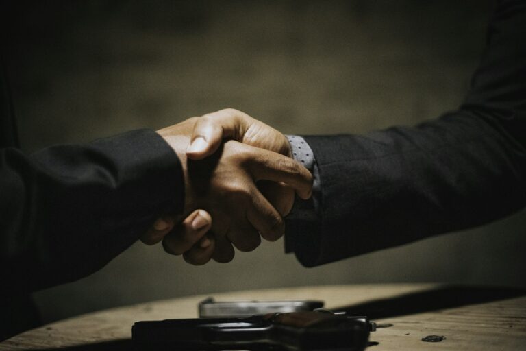 Aperto de mãos selando acordo em mesa de negociação