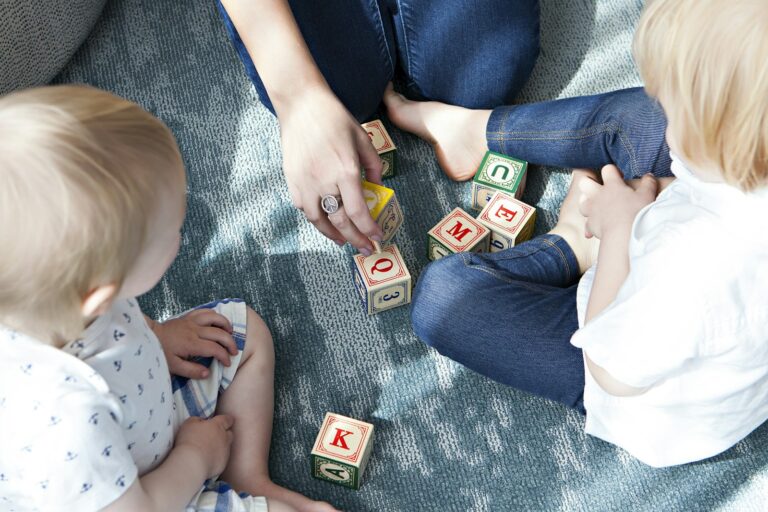 Crianças brincando com cubos de letras em atividade de aprendizagem