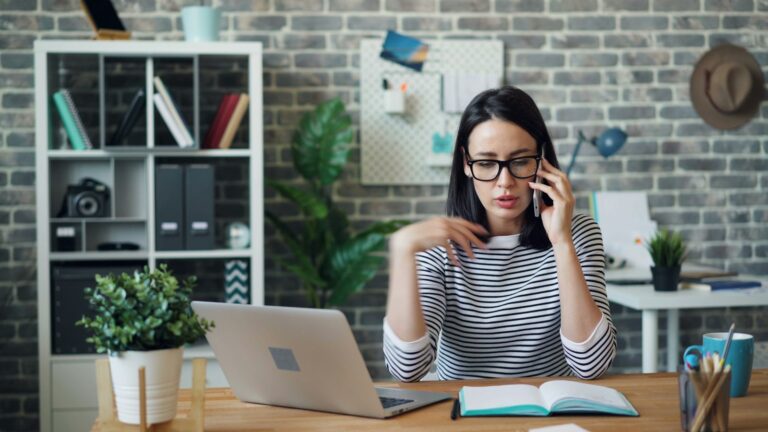 Profissional atendendo telefone em mesa de escritório