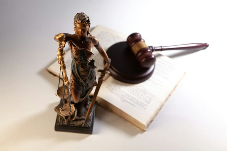 Estátua da justiça, martelo e livros de direito